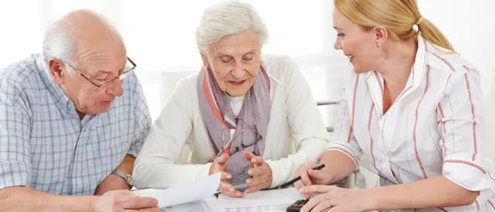 An elderly couple talking to their financial advisor