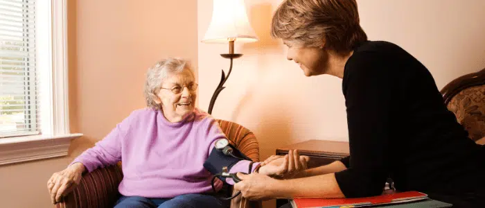 A home health care specialist takes a patient's blood pressure